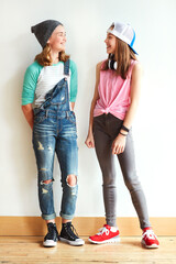 Fashion, talking and teenagers by wall for bonding, best friends or laughing together. Happy,...