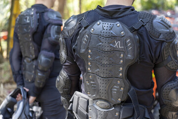 Focused man in black body armor and protective gear stands ready for an extreme sport. back protector ensures safety during outdoor athletic activity