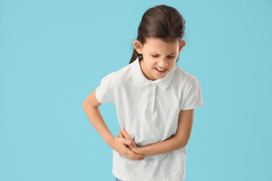 Teenage girl with appendicitis on blue background