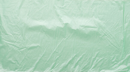 Obraz premium Crumpled light green plastic film surface forming textured background