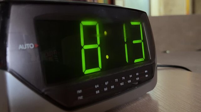 The digital alarm clock glows green while tuned to an inactive frequency. The internal speaker emits a steady, rhythmic hiss of white noise.