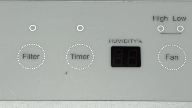This white control panel manages a dehumidifier and emits a sharp electronic beep when buttons are pressed. As the device runs, the internal fan creates a steady, comforting mechanical hum.