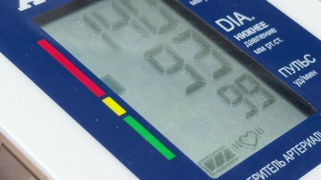 The blood pressure monitor finishes its reading and releases the air from the arm cuff. This action produces a steady, soft hissing sound as the pressure drops.
