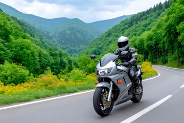 Motorcycle rider traveling mountain road through green forest