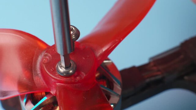 Close-up macro of screwing in propeller mounting screws on a DIY drone's brushless motor