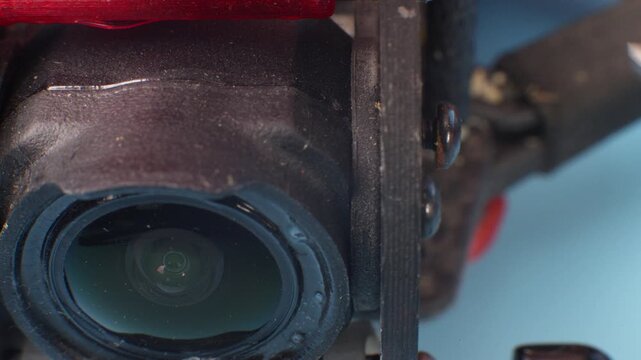 Close-up setup and installation of the FPV course camera on a self-assembled drone in a carbon frame. Close-up macro shot