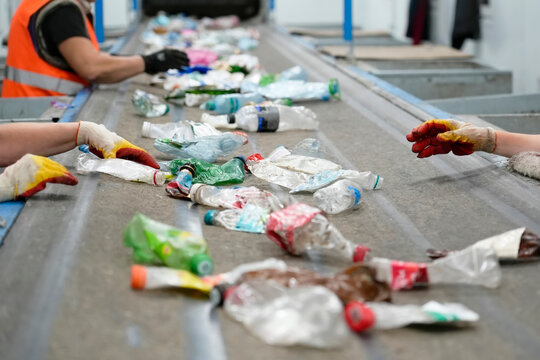 Manual sorting of plastic bottles from drinks and other liquids, workers in gloves will perform visual selection