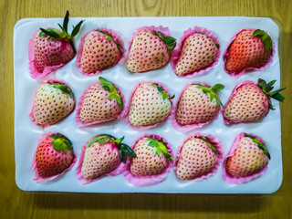 Fresh, ready-to-eat, special variety of white and pink strawberries in a protective box.