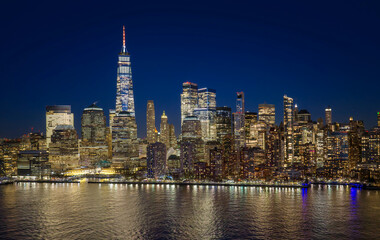Obraz premium New York City panoramic skyline at night. Manhattan skyline panorama. New York City at dusk and night. Manhattan skyscrapers at sunset and night. New York City panorama view at night.