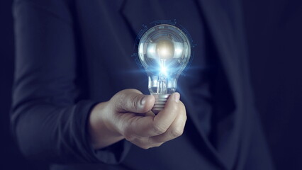 Artificial intelligence innovation concept with businessman holding glowing light bulb and digital AI interface overlay, representing smart technology, data processing.