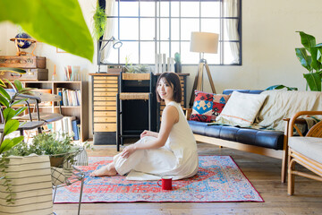 ラグに座るワンピースの女性