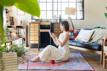 ラグに座るワンピースの女性