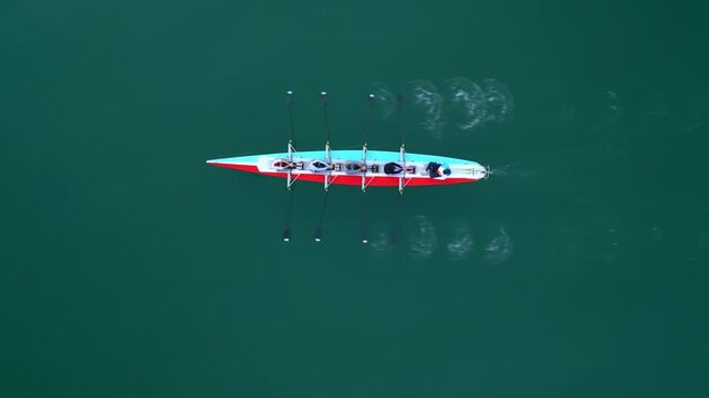 Sport Canoe with a team of four people rowing on tranquil water, Aerial view. High quality 4k footage