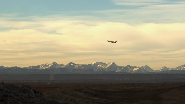 Sleek, stylish jet airplane takes off on hazy day from YYC mountains