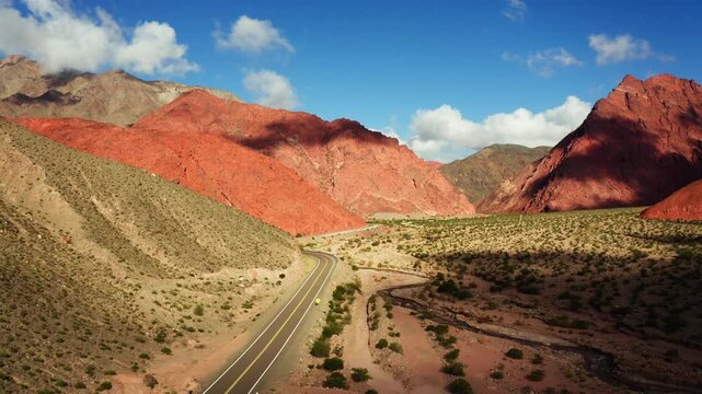 Wide aerial showing road cutting through desert valley on Ruta de los Seis Miles, Catamarca Argentina, dolly