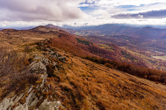 Autumn landscape in the Bieszczady with a wet muddy mountain trail on a cloudy and windy day.
