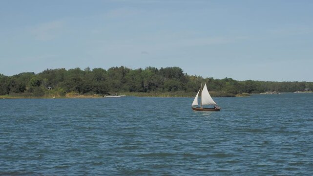 Small boat with sails floats on the river
