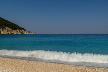 Obraz premium Waves Breaking at Myrtos Beach with the Green Headland, Kefalonia, Greece