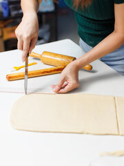 Obraz premium Closeup hand of woman bakers preparing use knife cut pastry pie dough on white table process making workflow ingredients flour homemade delicious sweet dessert bread baking cooking in bakery kitchen.