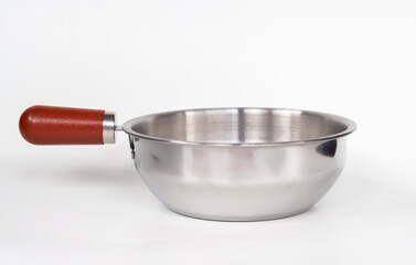 Stainless steel saucepan with wooden handle isolated on white background. Empty metal cooking pot for kitchen and culinary use. 
