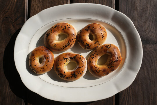 Freshly Baked Mini Bagels with Poppy Seeds on a White Plate
