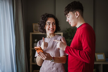 Mother and son bonding over shared smart phone content