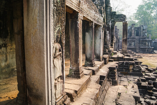 Temple grounds ruins with columns, Devata carving, Cambodia
