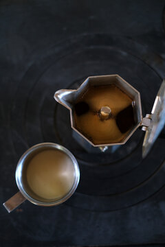 Overhead View of Moka Pot and Coffee Cup on a Dark Background