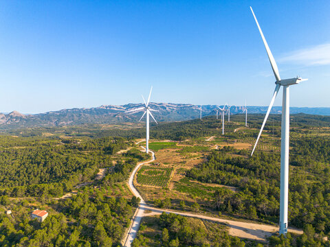 Drone aerial landscape showing wind turbine over a valley and road in the Terra Alta region of Catalonia Spain with renewable energy generation