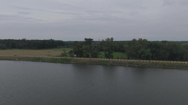 A serene lake scene with two objects in the water under an overcast sky
