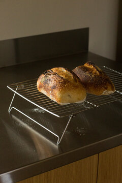 Freshly Baked Sourdough Bread Loaves Cooling on Wire Rack in Modern Kitchen
