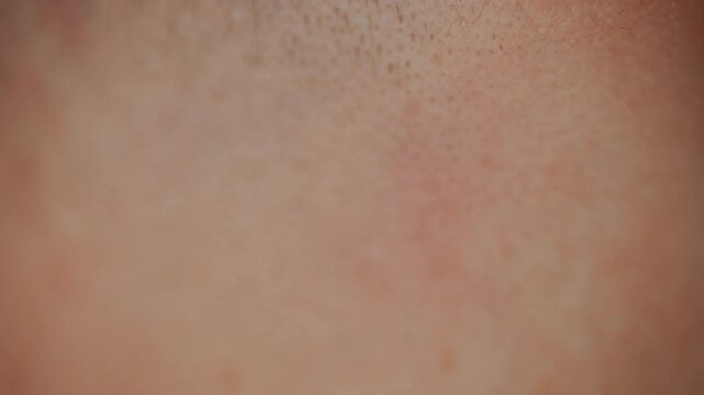 Close-up of electric razor shaving man's facial hair