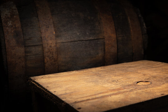 Warm barrel corner with wooden table under spotlight, welcoming amber glow, rustic backdrop ideal for beverage shots, marketing