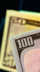 Close up of a hundred dollar bill with a fifty dollar bill in the background