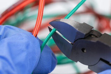 Technician man cutting electrical wires with nippers repair service, and install