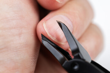 Nail clipper cutting hand finger isolated on white background