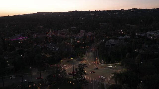 Aerial descending and panning shot of the luxurious Beverly Hills Hotel, the Pink Palace, at twilight in Beverly Hills, California. 4K