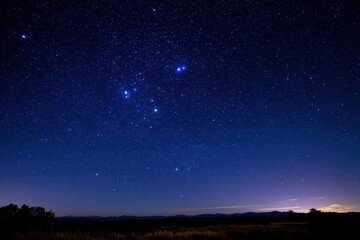 Fototapeta premium Astro nightscape highlighting the Southern Cross in a deep blue sky with distant silhouettes