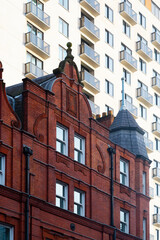 Historic red brick building facade against modern apartment block in London