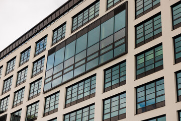 Fototapeta premium Modern office building facade with grid of glass windows