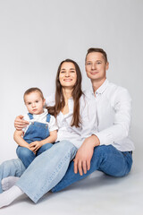 Adorable Smiling Happy Caucasian Parents Mom and Dad With Little Son Child Kid Boy On Casual Jeans Clothing  Hugging Gladly Together Over White To Convey Traditional Family Relationships Ideas.