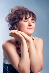 Portrait of Winsome Sexy Sensual Caucasian Woman With Bright Makeup Curly Hairdo Posing With Necklace Beads Over White Background As Concept of Cosmetics, Makeup and Rejuvenation.