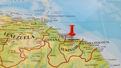Naklejka premium View of Paramaribo, is the capital and largest city of Suriname, located on the banks of the Suriname River in the Paramaribo District, on a geographical map of America, marked with red push pin