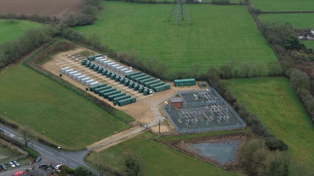 Aerial view of a substation nestled amidst verdant fields, a stark contrast between industrial precision and natural serenity, Enderby, Leicester, United Kingdom.