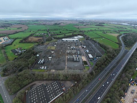 Aerial view of a vast industrial landscape meets the verdant countryside under a muted sky, Enderby, Leicester, United Kingdom.