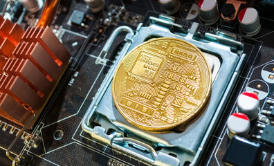 Golden bitcoin lying above the electronic computer details. Blockchain technology concept, bitcoin mining concept