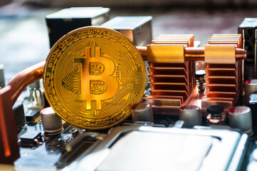 Shining golden bitcoin among computer details. Business concept of digital cryptocurrency, blockchain technology, bitcoin mining
