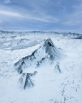 Aerial view of stark white snow contrasting against the dark, jagged peaks under a pale sky, Reykjav&Atilde;&shy;kurborg, Iceland.