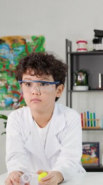 Young Boy in Lab Coat Performing Bernoulli's Principle Science Experiment