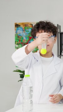 Young Boy Performing Bernoulli's Principle Science Experiment with Ping Pong Ball